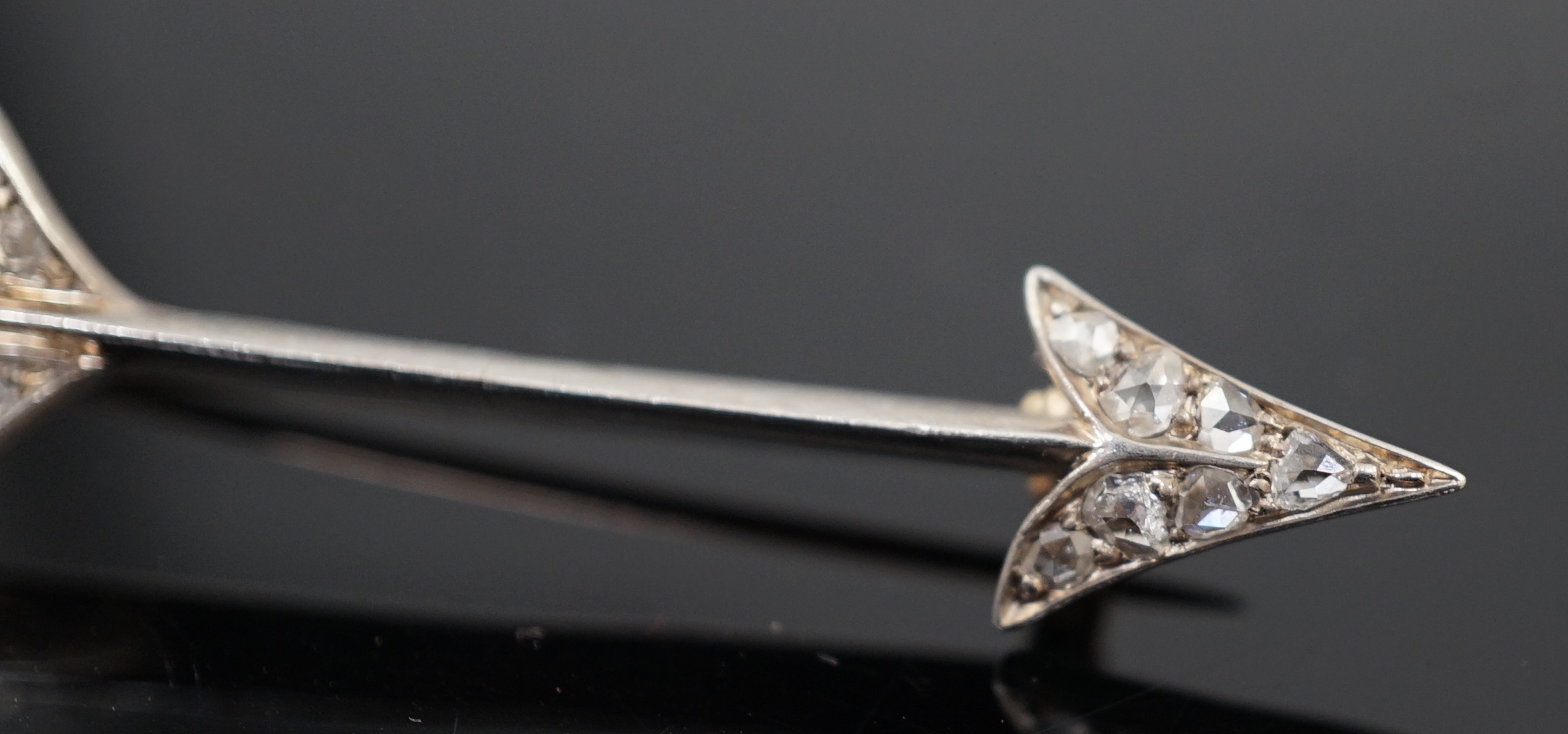 An early 20th century gold, platinum and rose cut diamond cluster set arrow brooch